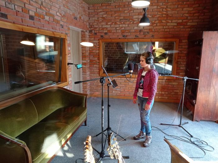 Dziewczynka przy mikrofonie w studiu nagrań